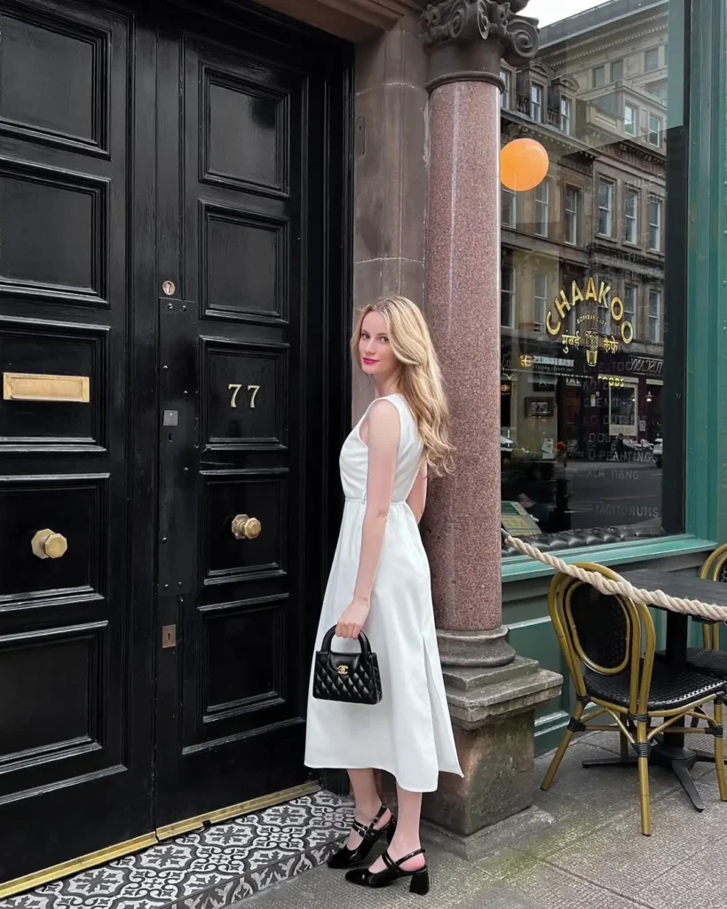 20 Preppy Outfit Ideas for a Polished Travel Wardrobe 12 #11. White Midi Dress and Chanel Handbag – Elegant Prep with Understated Drama