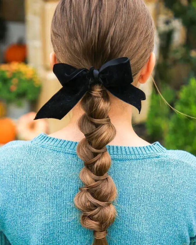 #14. Sleek Wrapped Braid with Velvet Bow Accent