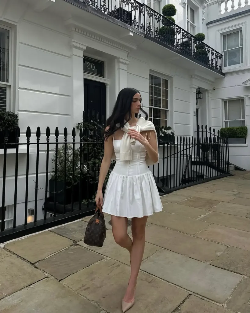 20 Preppy Outfit Ideas for a Polished Travel Wardrobe 17 #16. White Corset Mini and Draped Sweater – Uptown Prep with Couture Precision