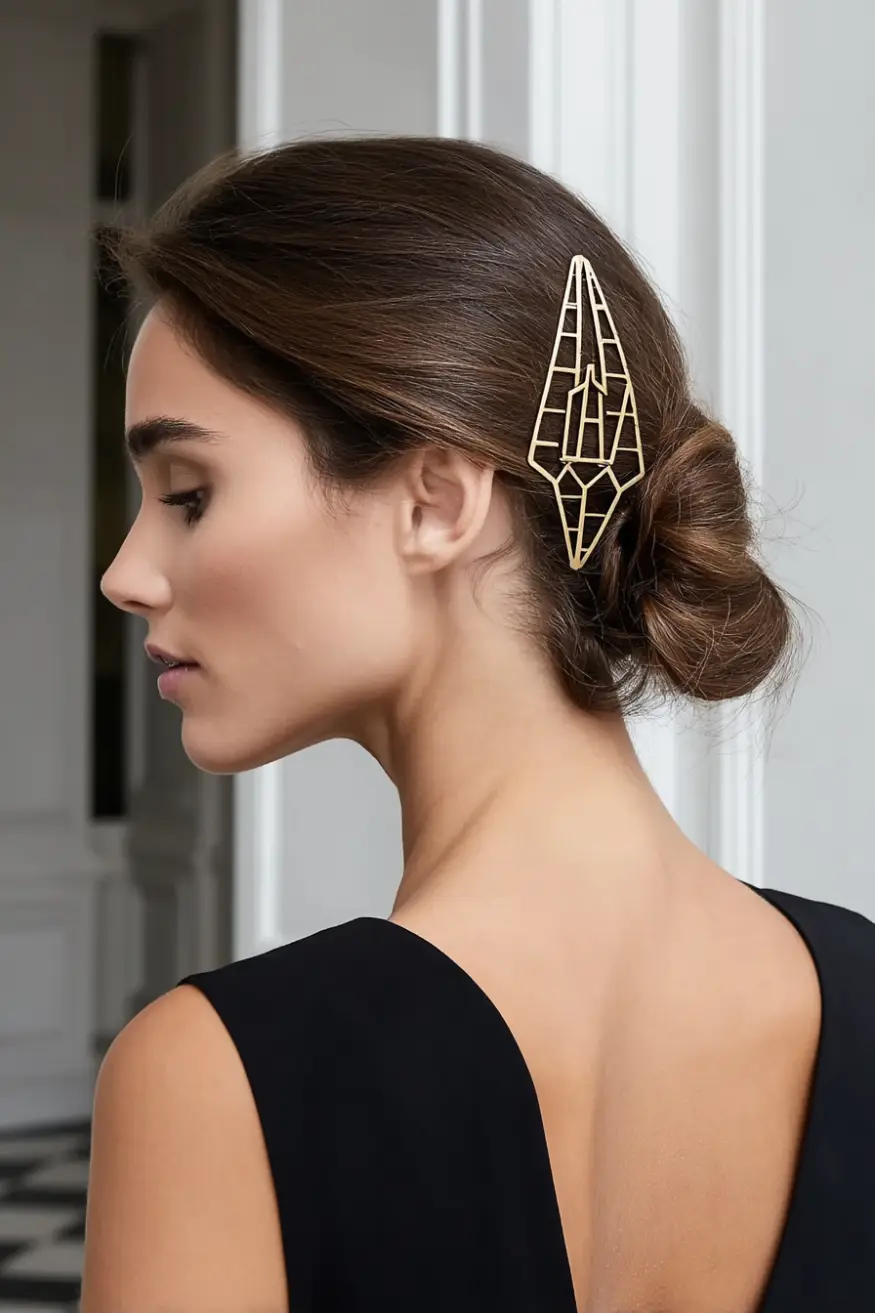 #17. Sleek Low Chignon with Sculptural Gold Hairpin