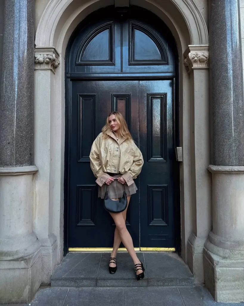 20 Preppy Outfit Ideas for a Polished Travel Wardrobe 20 #19. Boxy Trench and Pleated Mini – Edgy Prep with Retro Outerwear Influence