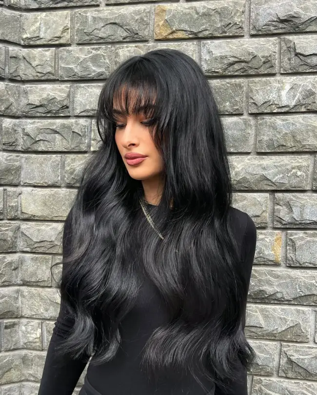 #6. Long Jet-Black Waves with Sheer Curtain Bangs