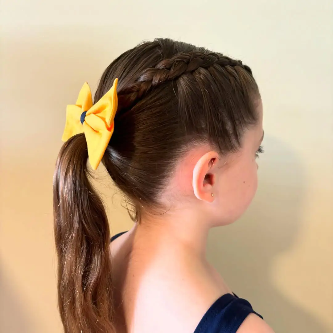 22 Refreshing Hairstyles for Swimming: Stylish Looks That Stay Put in the Water 14 Side Dutch Braid into Sleek Ponytail with Yellow Bow