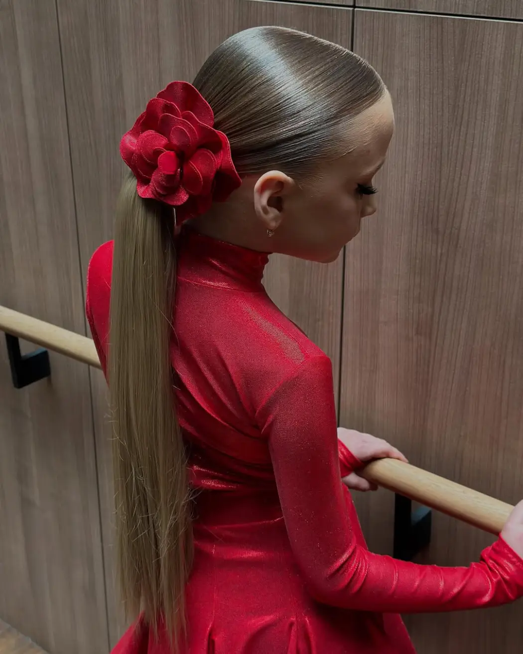 26 Bold Dance Hairstyles: Show-Stopping Styles for Stage and Studio 9 Sleek Ponytail with Bold Red Flower Accent