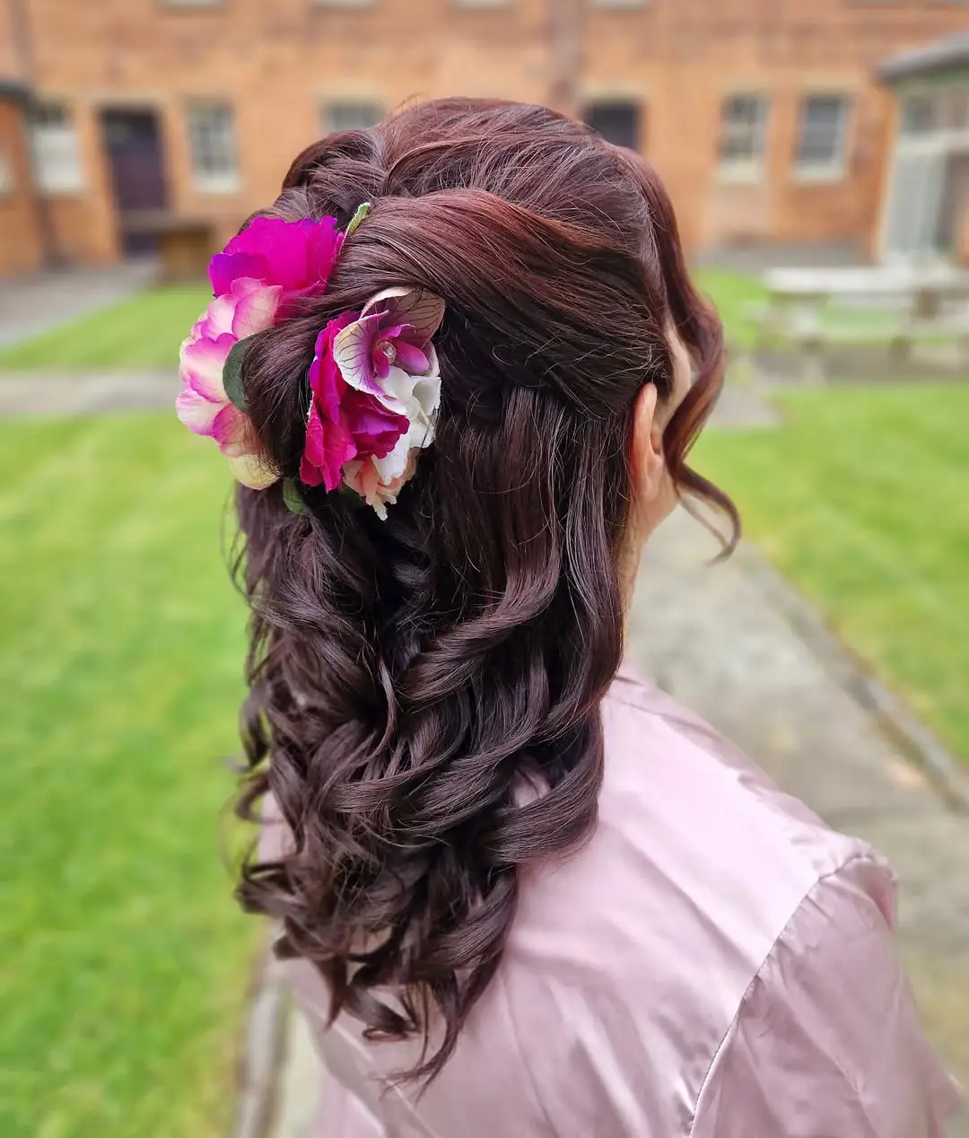 Twisted Half-Up Curls with Bold Floral Accent
